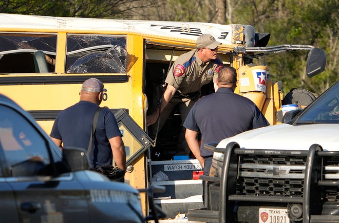 A state trooper looks at a fatal school bus crash on SH 21 near Caldwell Road Friday March 22, 2024.