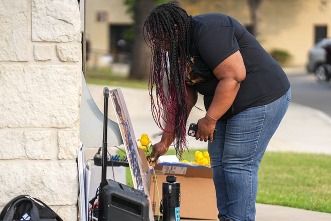 Shanta Miller places a flower in front of a photo of her son Malachi Williams at a vigil outside San Marcos City Hall on Thursday, April 25, 2024 in San Marcos, Texas. Williams was killed by San Marcos Police on Thursday, April 11, 2024.