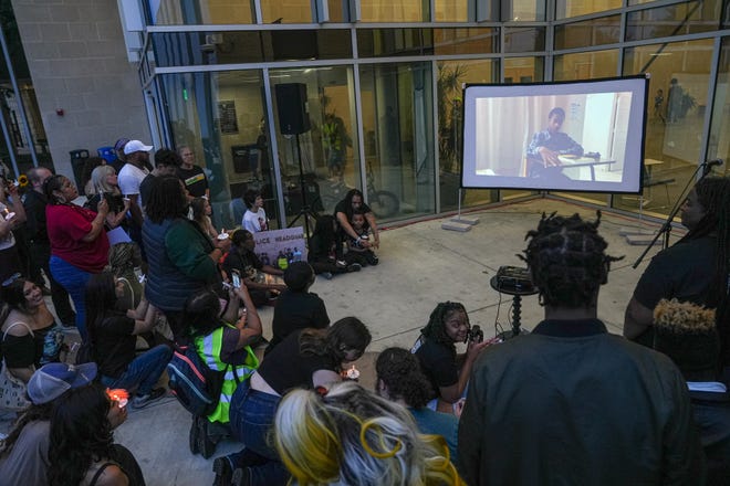 Community and family members watch home videos of Malachi Williams at a vigil outside the San Marcos Public Library on Thursday, April 25, 2024 in San Marcos, Texas. Williams was killed by San Marcos Police on Thursday, April 11, 2024.
